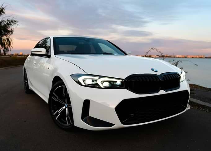 White BMW on Road at Sunset
